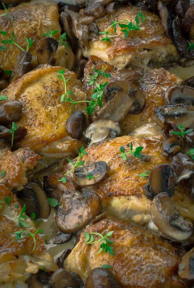 Close up of Crispy Roasted Chicken with Mushrooms and Cream with thyme sprigs on top.