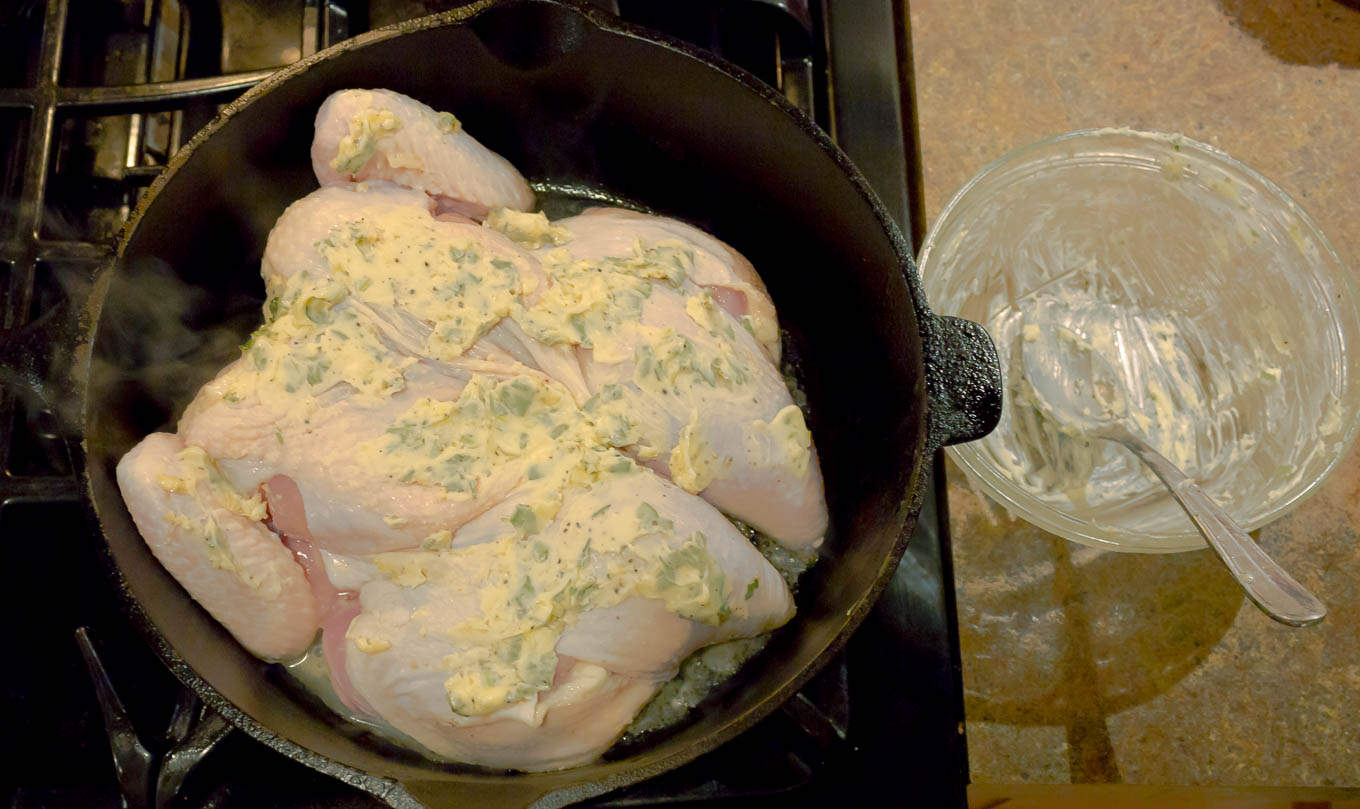 Chicken being browned in a dutch oven for Whole Roasted Spatchcock Chicken with Sage Brown Butter