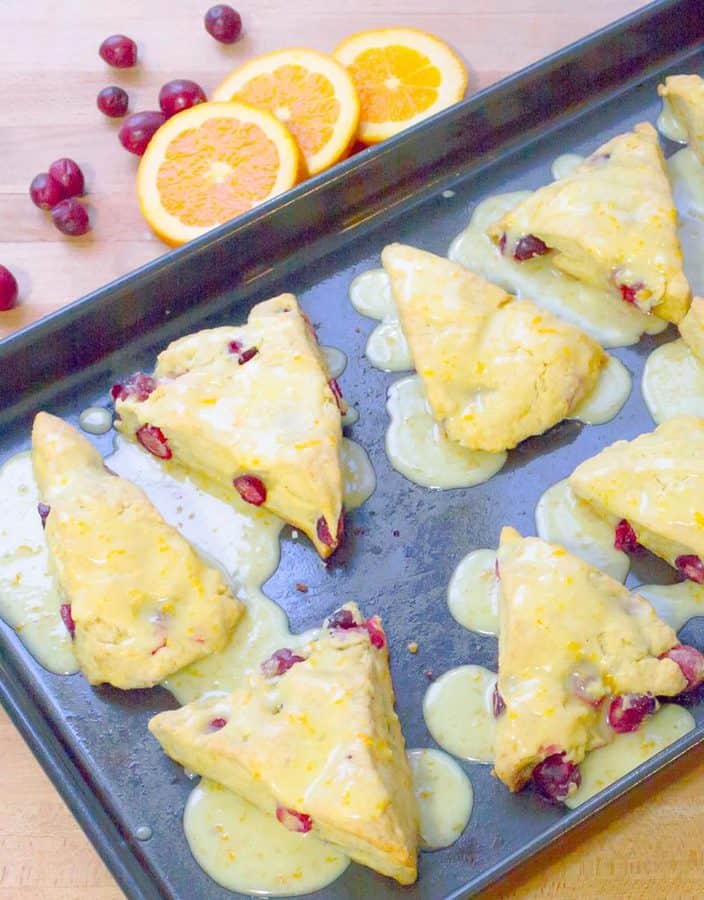 Fresh Cranberry Orange Scones on baking dish with drizzled icing.
