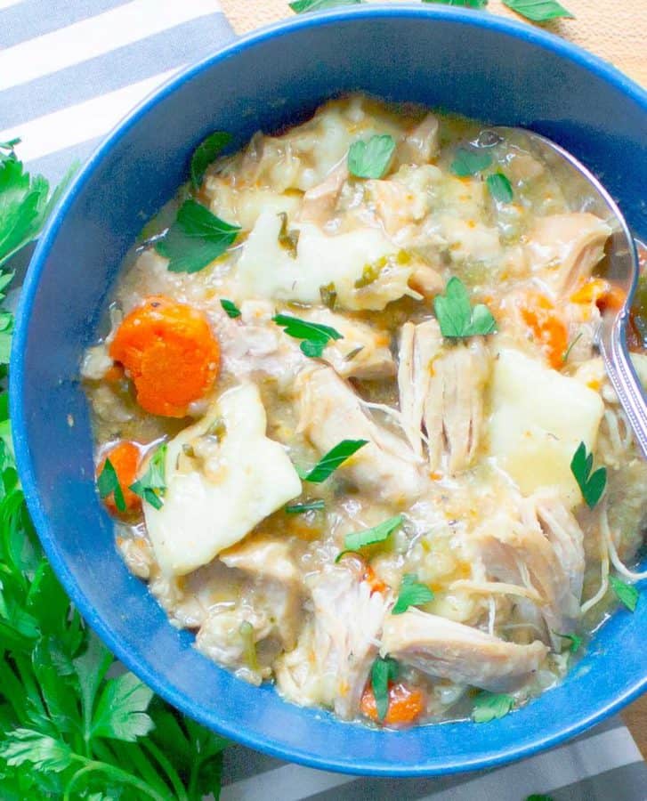 Slow Cooker Chicken and Dumplings from Scratch in blue bowl with parsley