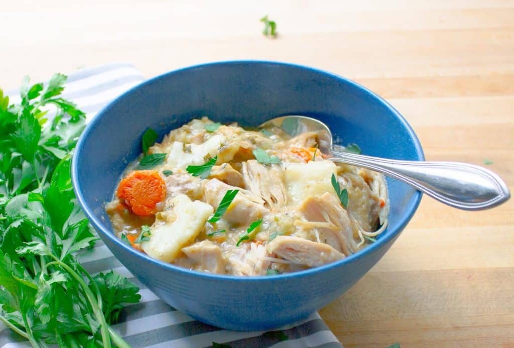 Slow Cooker Chicken and Dumplings from Scratch in blue bowl with striped napkin