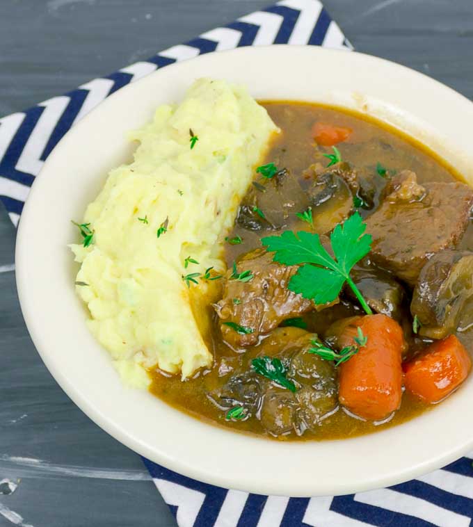 Beef and Guinness Stew in white bowl with striped napkin