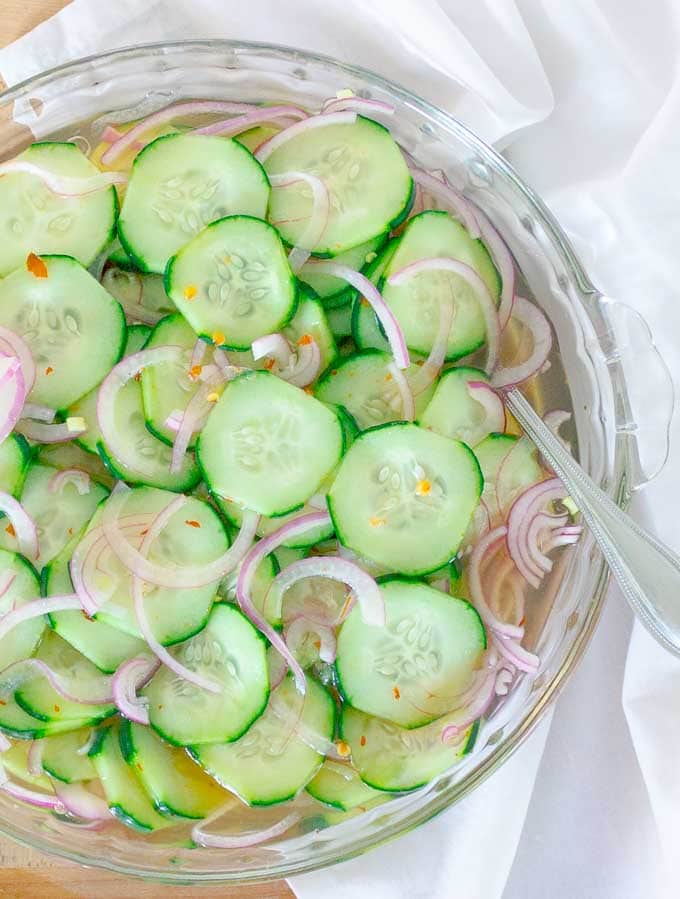 Pickled Cucumber and Red Onion Salad in clear bowl on a white cloth