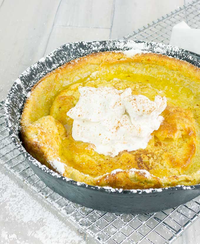Pumpkin Pie Dutch Baby  in a cat iron skillet with whipped cream