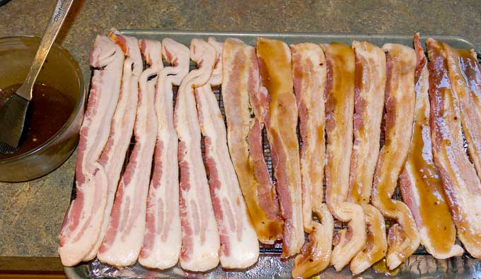 raw bacon on baking sheet with half glazed