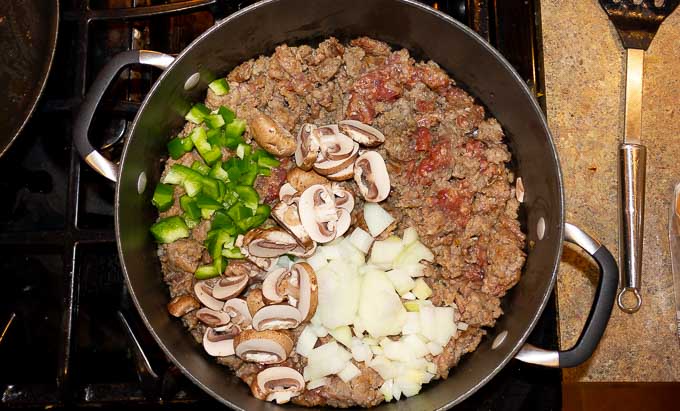 ground sausage, onion, pepper, and mushrooms in a skillet