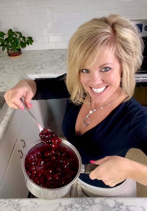 Jenifer holding a pot of homemade cherry pie filling