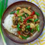 Thai Style Cashew Chicken on brown plate with yellow napkin and chopsticks