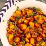 Easy Roasted Butternut & Acorn Squash with Sage Brown Butter in white bowl with a blue strip napkin