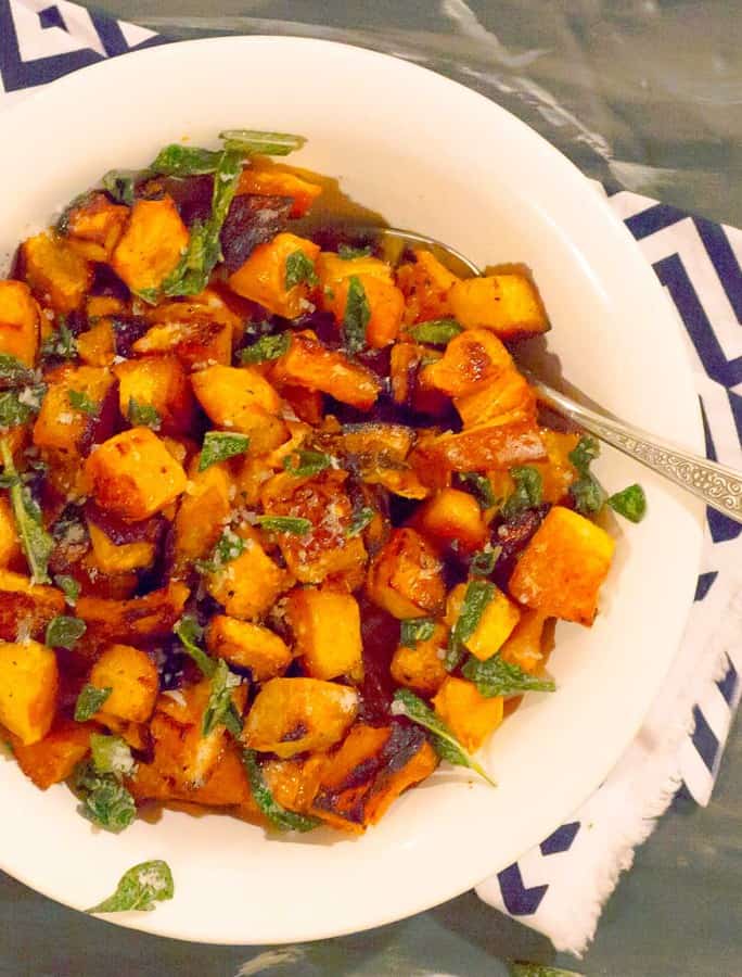 Easy Roasted Butternut & Acorn Squash with Sage Brown Butter in white bowl with a blue strip napkin