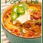 Instant Pot Pressure Cooker Red Pork Chili in a bowl with ganishings in a blue bowl on a gray striped napkin.