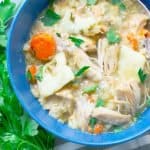 Slow Cooker Chicken and Dumplings from Scratch in a blue bowl with parsley