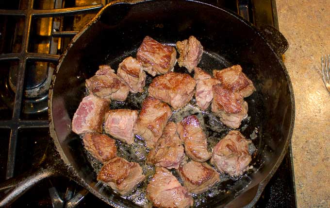 Beef being browned in cast iron dutch oven