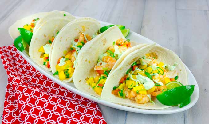 5 Spicy Shrimp Tacos with Mango Salsa on white oval platter