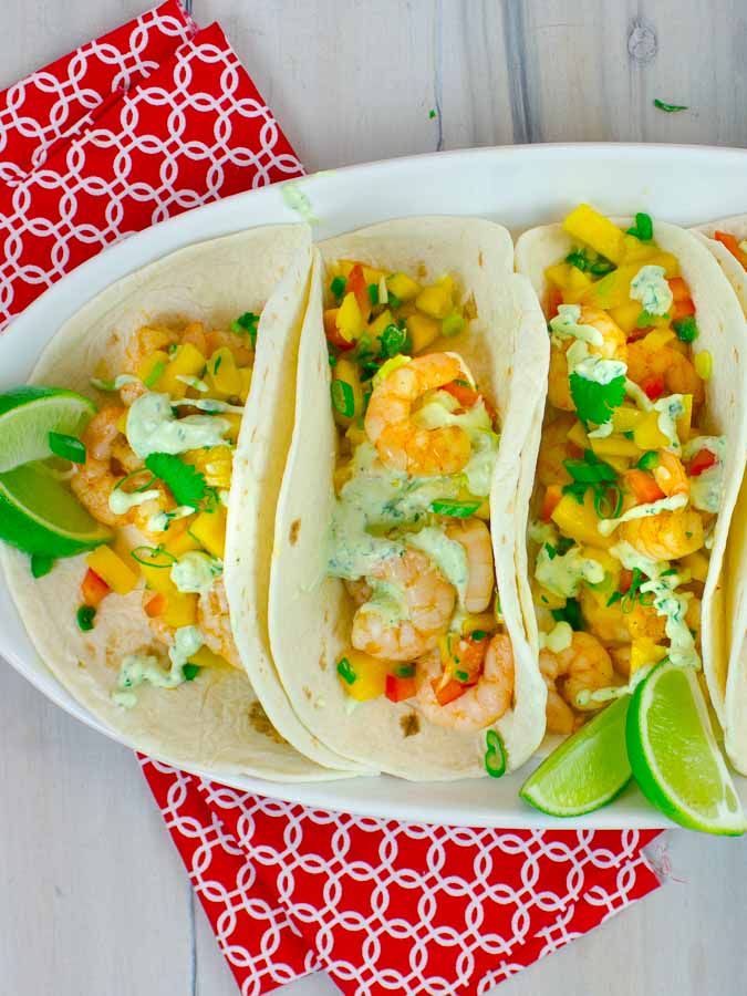 3 Spicy Shrimp Tacos with Mango Salsa on white oval platter