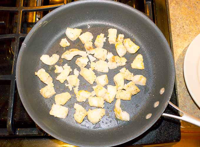 pieces of cod being browned in skillet