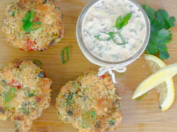 3 Baked Fresh Salmon Cakes (Salmon Patties) on wood board with spicy remoulade