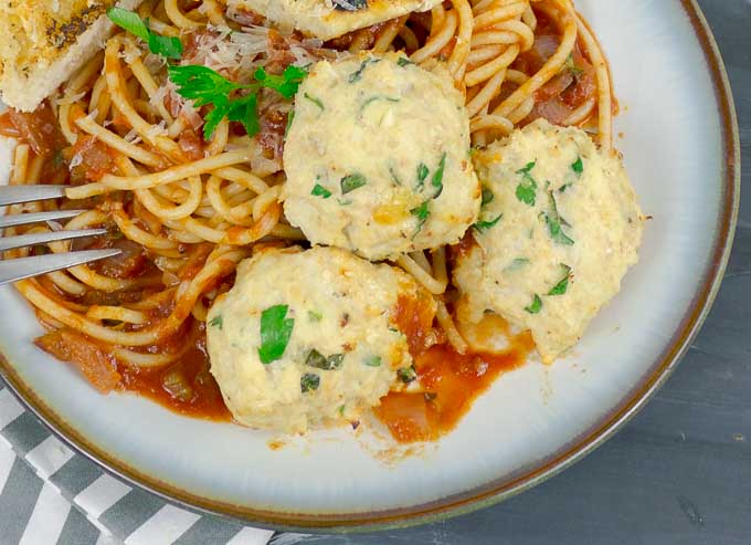 three Baked Chicken Ricotta Meatballs on pasta with Homemade Red Sauce