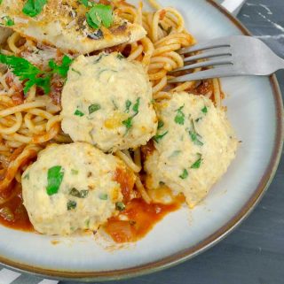 three Baked Chicken Ricotta Meatballs on pasta and red sauce