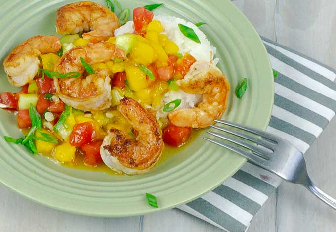 green plate of Garlic Shrimp with Mango Cucumber Salsa and Coconut Rice
