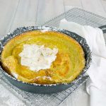 Pumpkin Pie Dutch Baby in a cat iron skillet with whipped cream