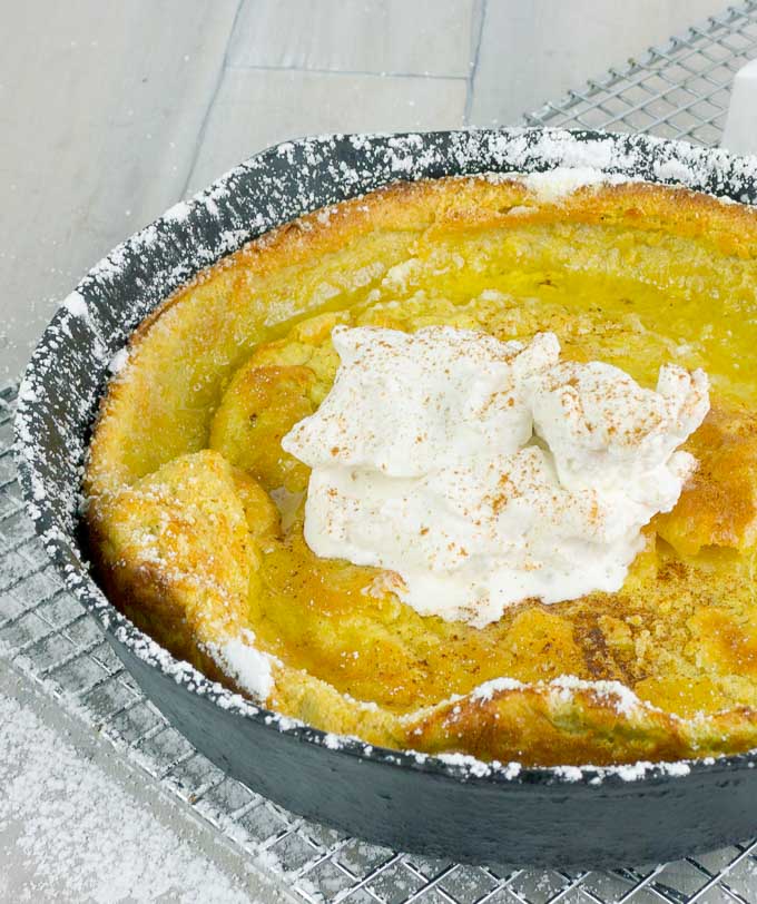 Pumpkin Pie Dutch Baby  in a cat iron skillet with whipped cream