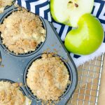 two apple streusel muffins and a sliced apple