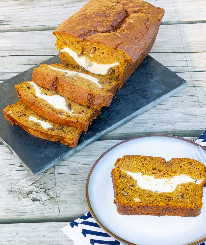 Sliced loadt of Cream Cheese Stuffed Pumpkin Bread with piece on a plate