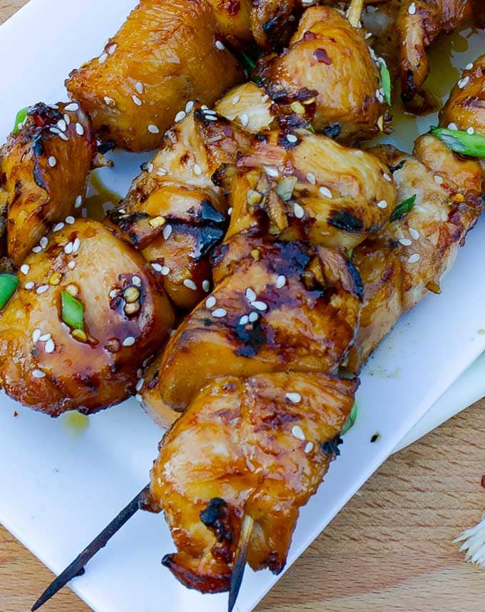 three Grilled Asian Chicken Kabobs on a white platter