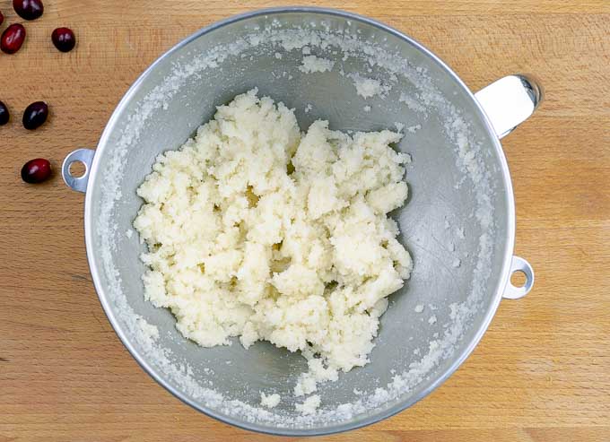 sugar and butter being creamed in a metal mixing bowl.