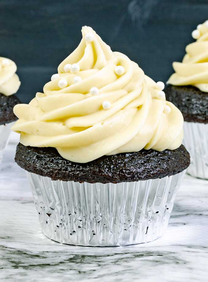 close up of a Guinness Dark Chocolate Cupcake with Irish Cream Cream Cheese Frosting in a silver wrapper