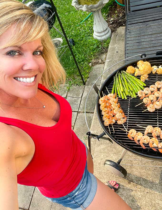 Jennifer next to a barbecue grill making grilled bang bang shrimp