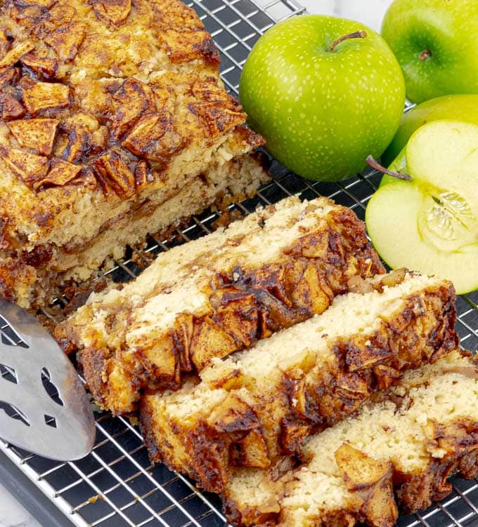 Apple cinnamon swirl loaf on wire rack with three pieces cut