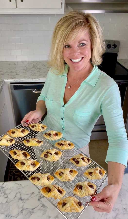 Jennifer holdig a rack of Chocolate Almond Croissant Puffs