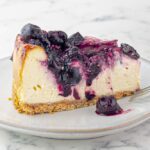 piece of Cherry Swirl Cheesecake with Graham Crust on a small white plate