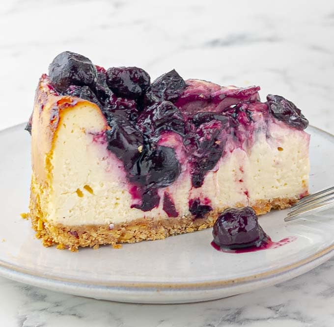 piece of Cherry Swirl Cheesecake with Graham Crust on a small white plate