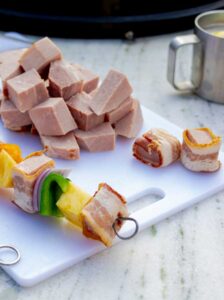 raw ingredients for Bourbon Bacon Ham and Pineapple Kabobs on a skewer