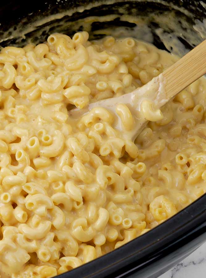 Extra Creamy Slow Cooker Macaroni and Cheese in black crock pot