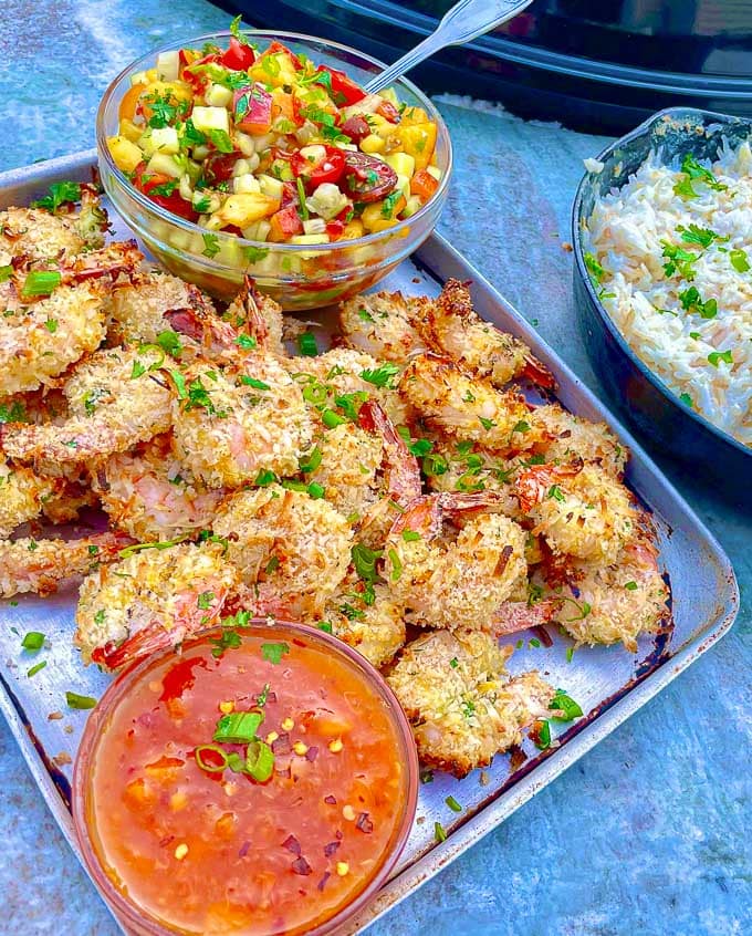 Crispy Grilled Coconut Shrimp with Peach Sauce and Coconut Sticky Rice on a baking sheet with peach tomato salad