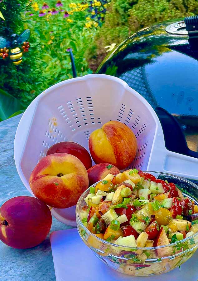 glass bowl of summer peach and tomato chop salad