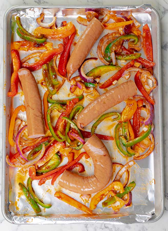 sausages and peppers on baking sheet ready to be cooked