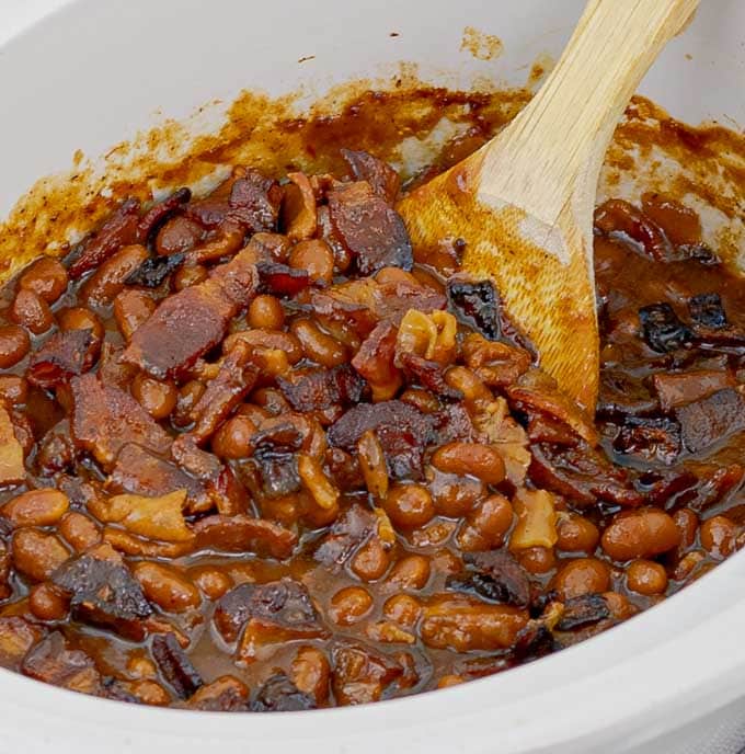up close white crockpot of Slow Cooker Bourbon Bacon Baked Beans