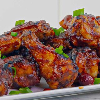 close up of cranberry bbq wings on white plate