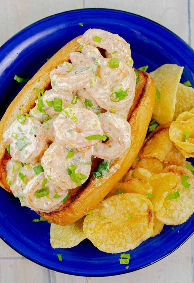 The Best Shrimp Roll with chips on a blue plate