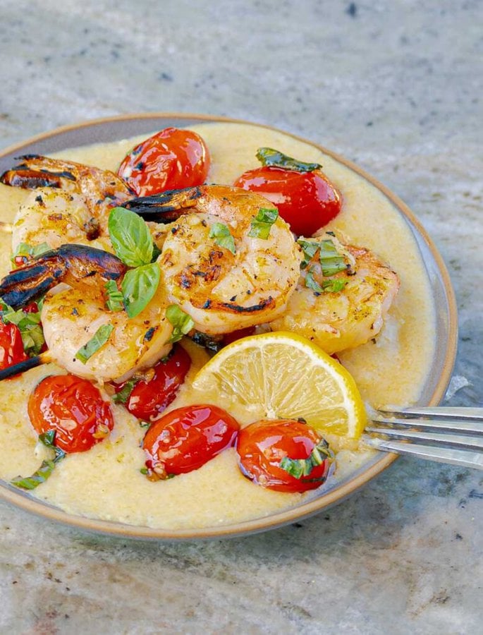 Grilled Italian Shrimp and Parmesan Polenta with Blistered Tomatoes on a grey plate